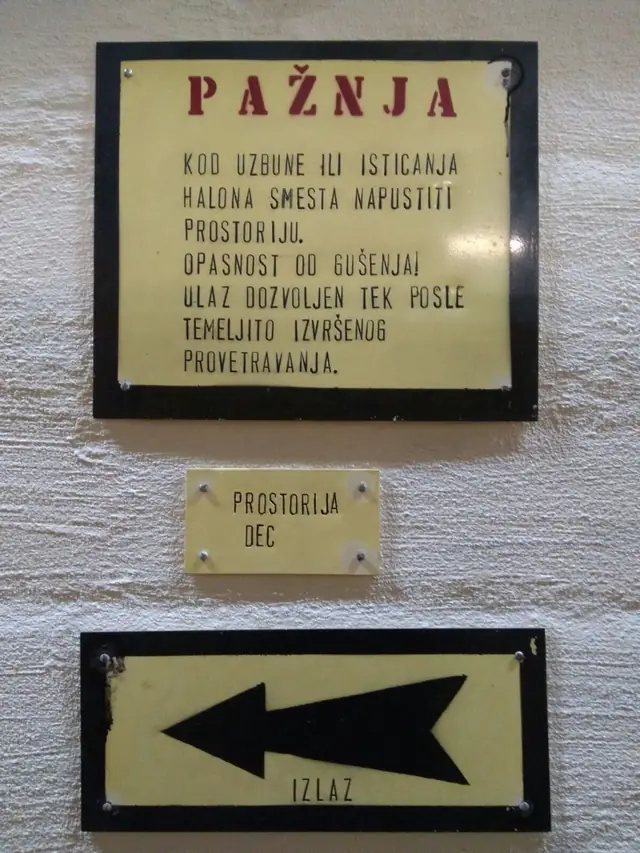 Original warning plaque and exit sign inside the facility